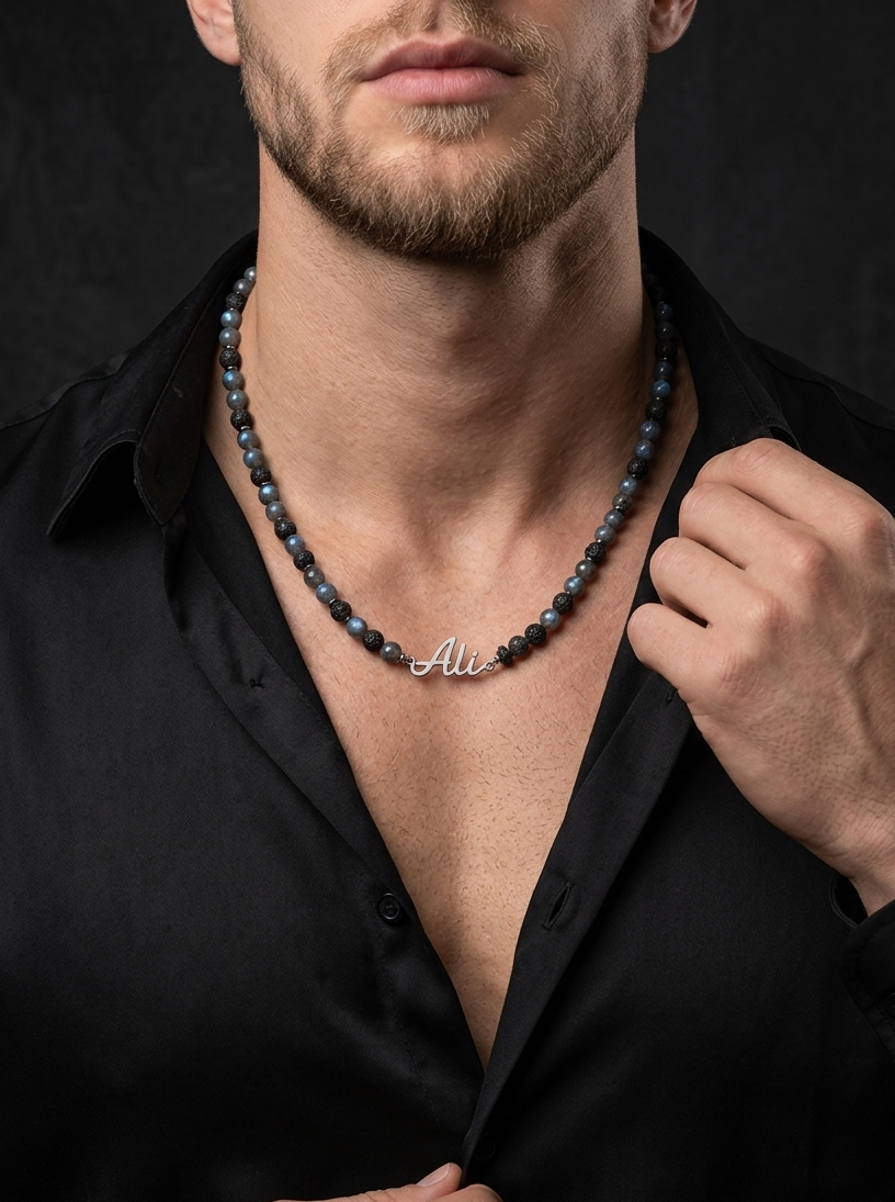 Man wearing a black shirt and a necklace with a visible brand name against a dark background