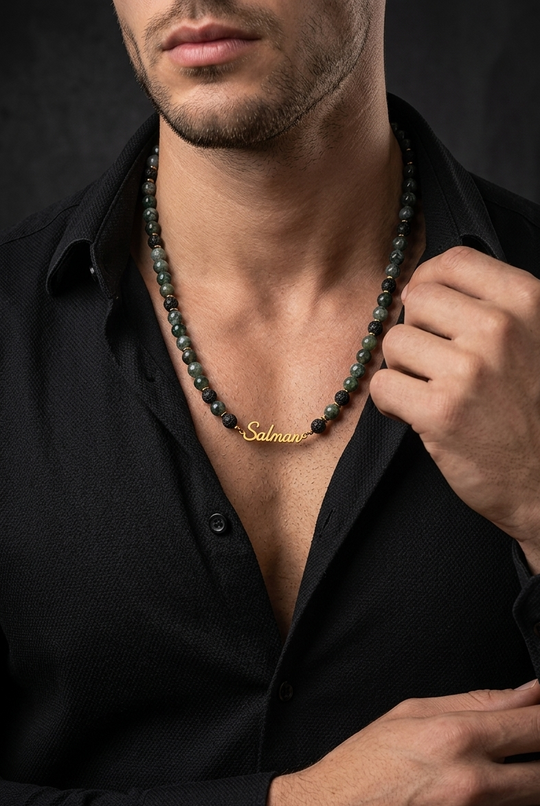 Man wearing a black shirt with a necklace featuring a gold tag.