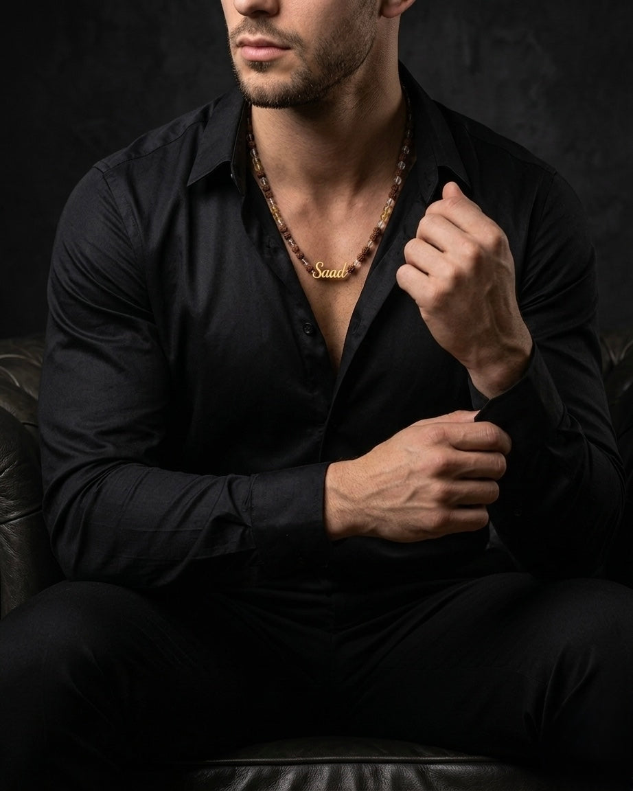 Man wearing a black shirt and a necklace with a dark background