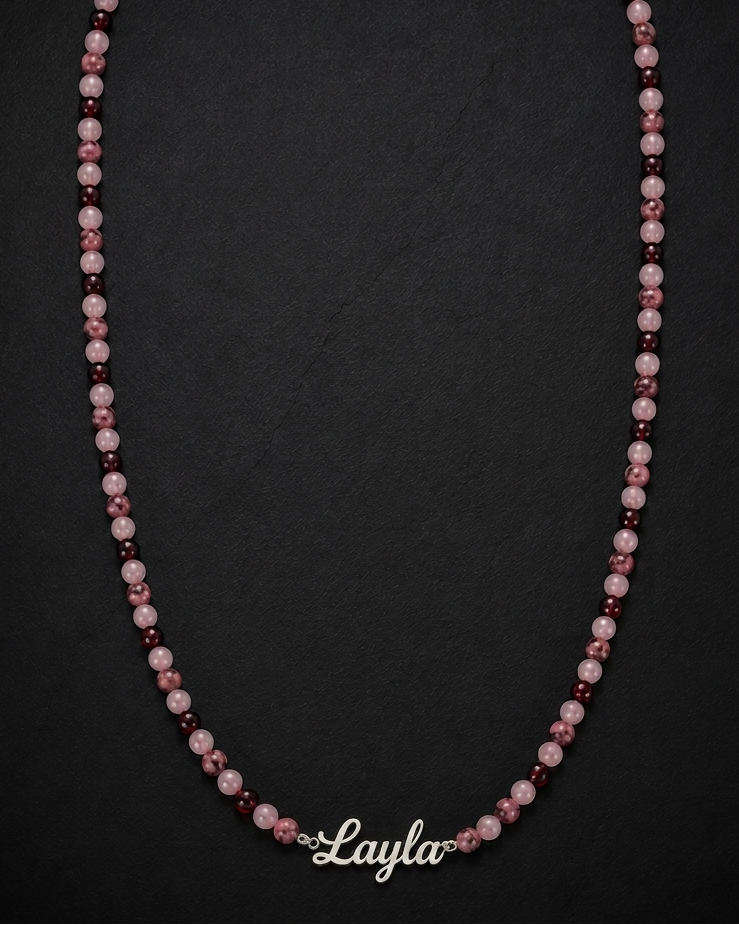 Necklace with pink and purple beads on a black background, branded 'Layla'.