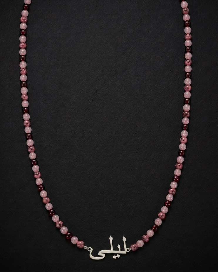Necklace with pink and red beads on a dark background