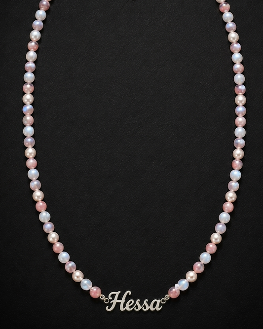 Pearl necklace with 'Hessa' branding on a black background
