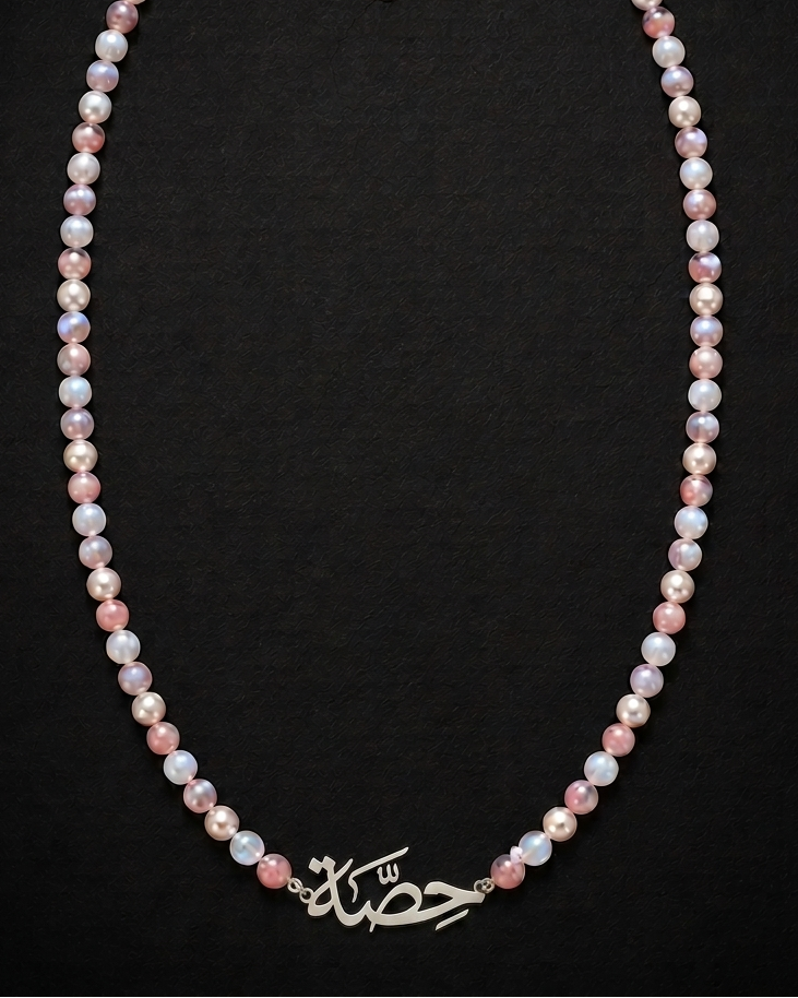 Pearl necklace with a silver clasp on a black background