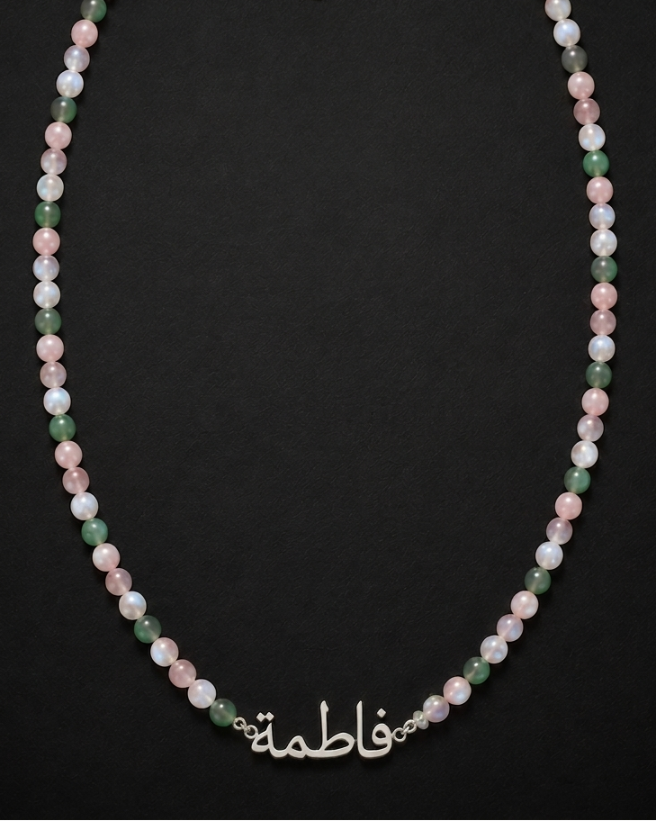 Necklace with multicolored beads and a silver clasp on a black background