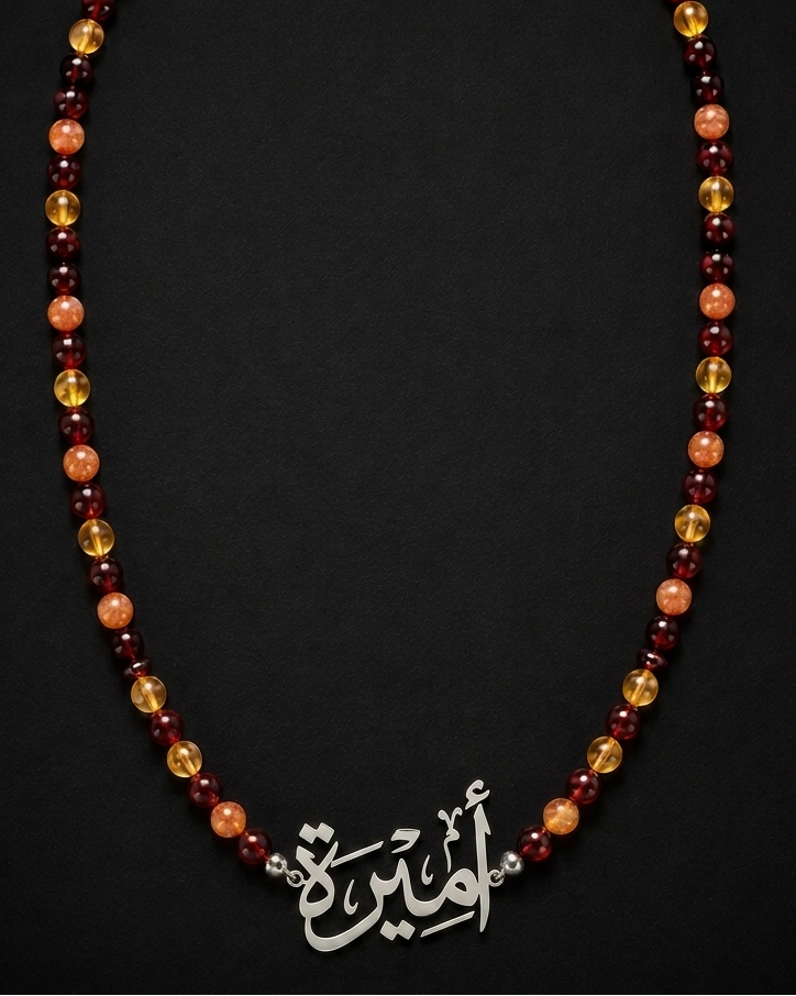 Necklace with beads and a silver pendant on a black background