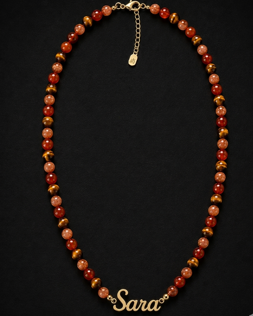 Necklace with red and gold beads and a 'Sara' charm on a black background