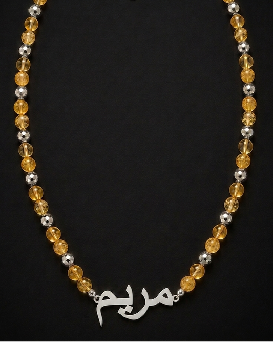 Necklace with yellow and silver beads on a black background