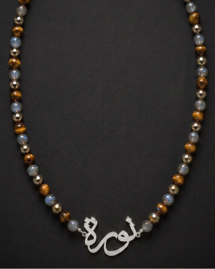 Necklace with beads and a silver pendant on a dark background
