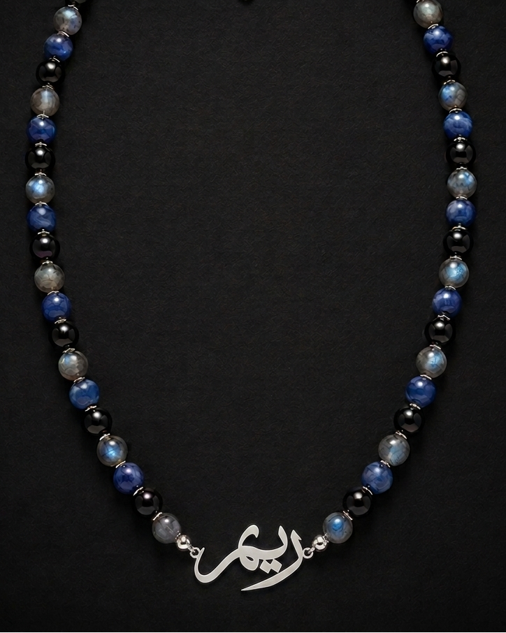 Necklace with blue and black beads on a dark background