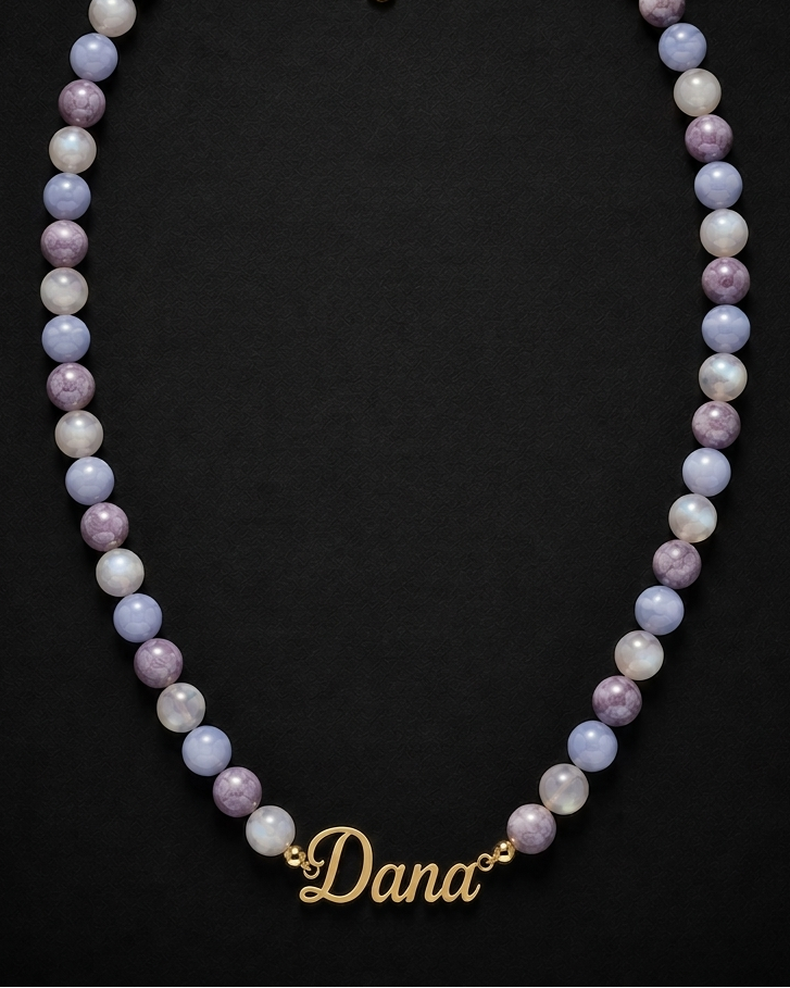 Necklace with multicolored beads and a gold 'Dana' name tag on a black background