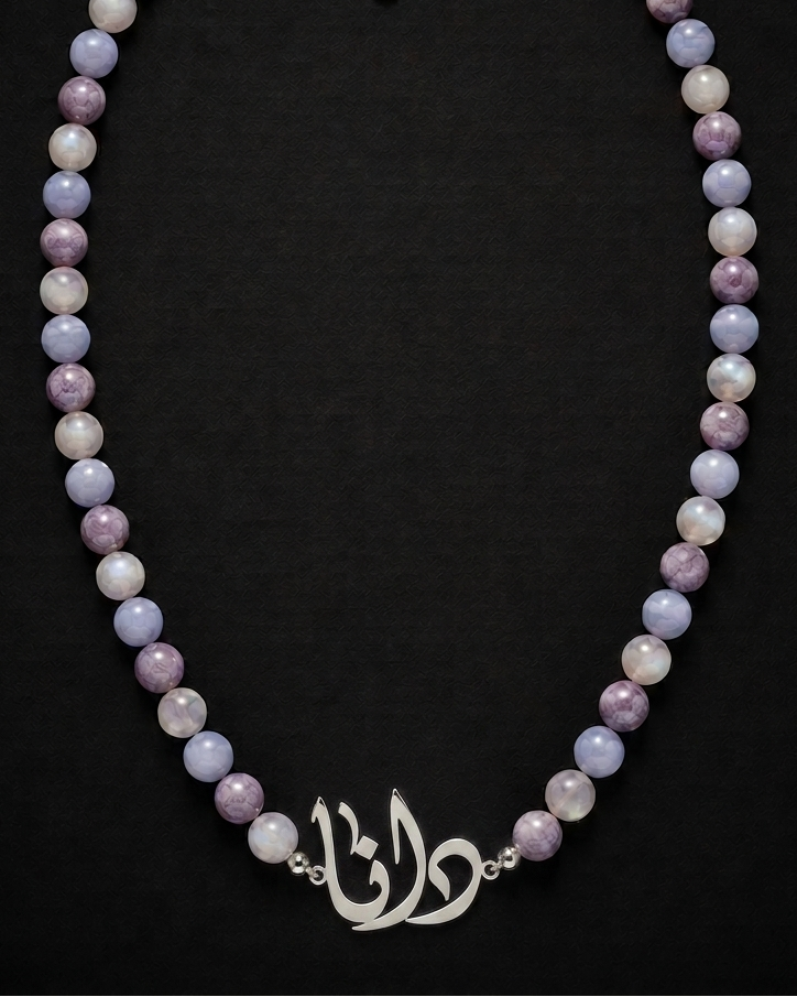 Necklace with multicolored beads and a silver clasp on a black background