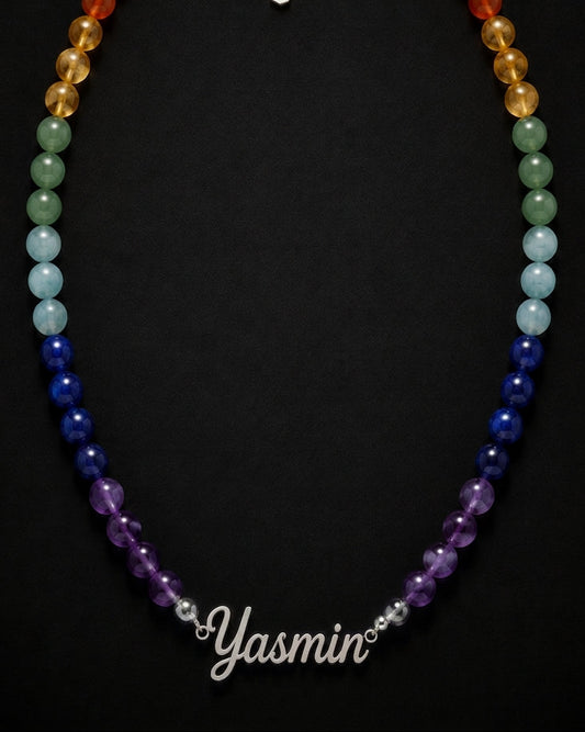Necklace with multicolored beads on a black background, branded 'Yasmin'.