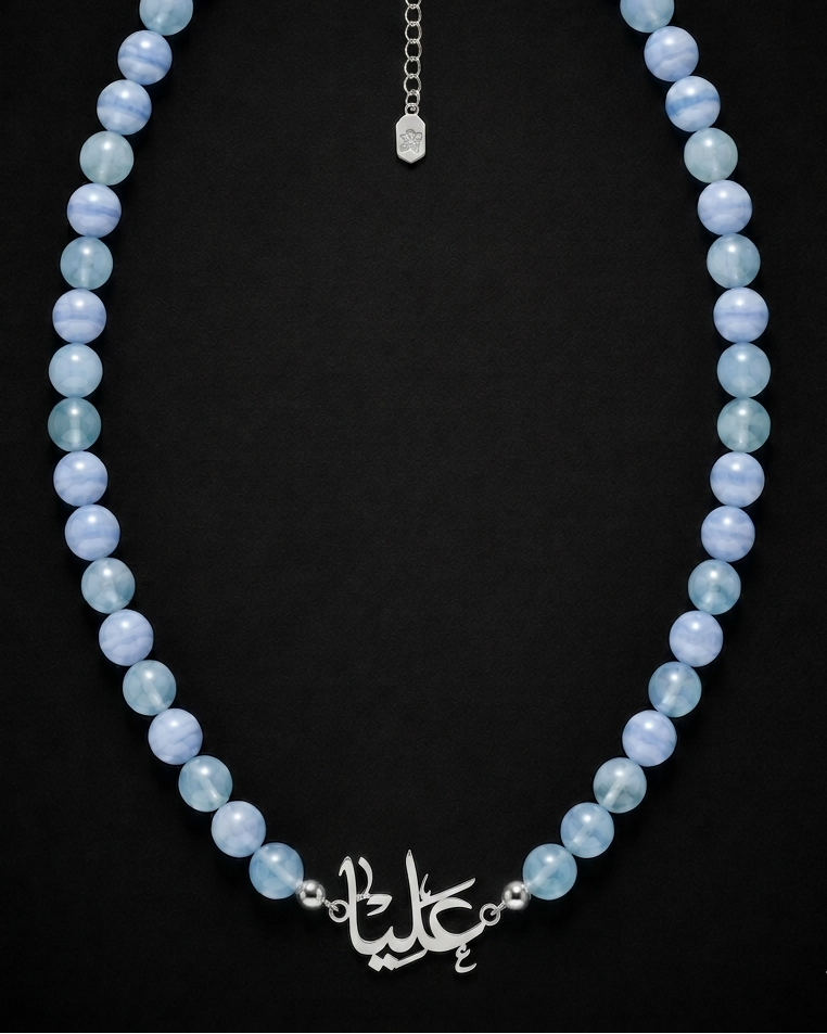 Blue beaded necklace with silver clasp on a black background