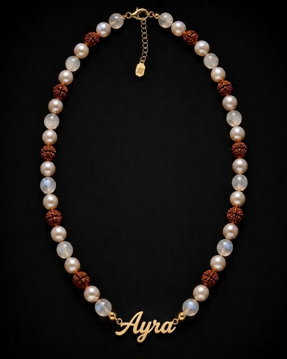 Pearl necklace with brown beads and 'Ayra' charm on a black background