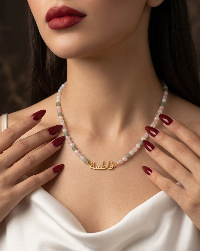 Woman wearing a gold necklace with a pearl choker, close-up of neck and hands.