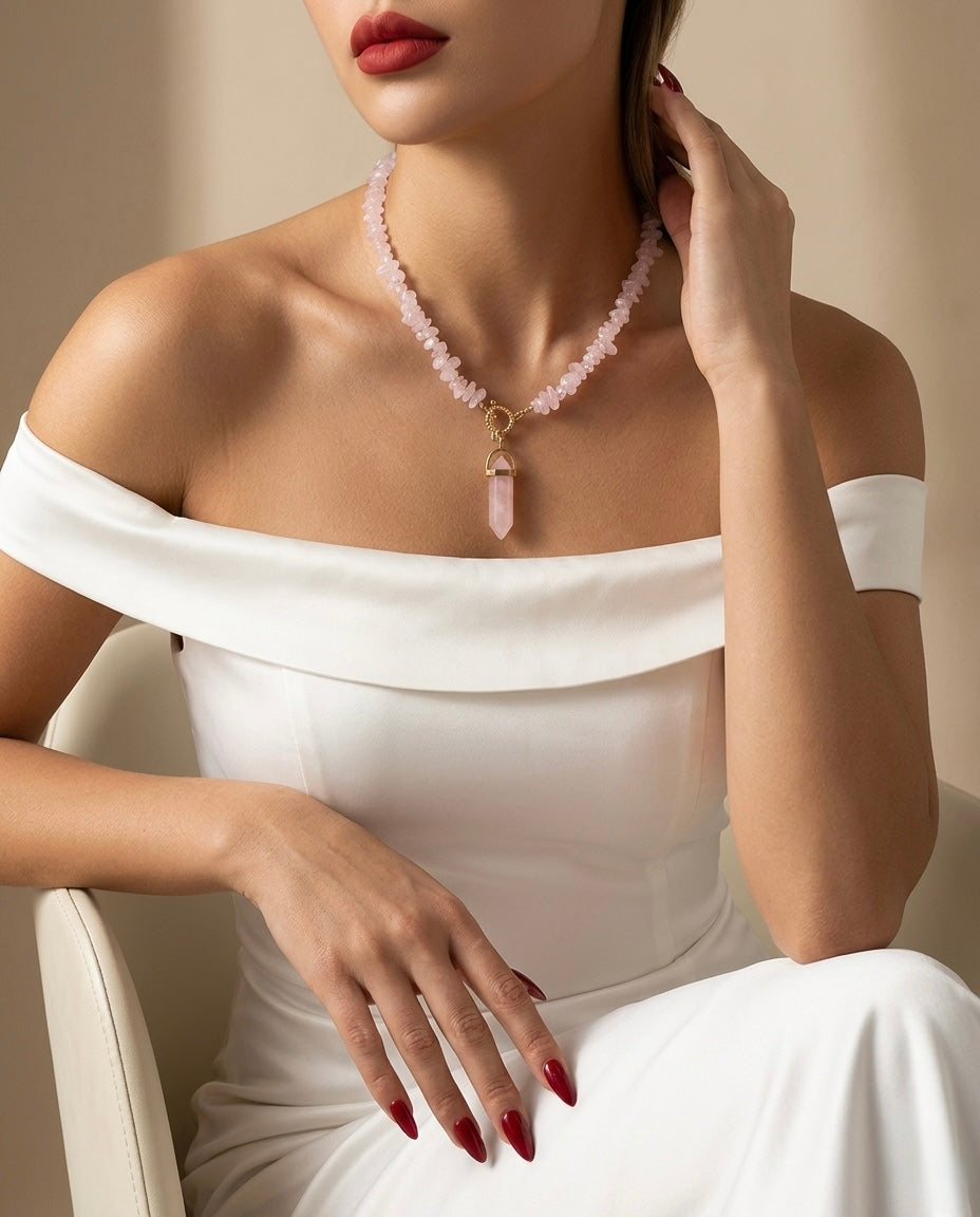 Woman wearing a white off-shoulder dress and a necklace with a pink pendant.