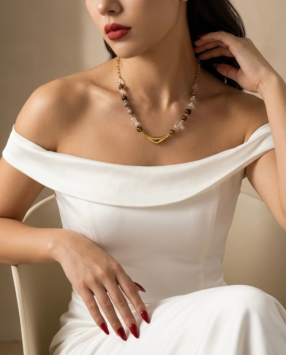 Woman wearing a white off-shoulder dress and a necklace with a neutral background