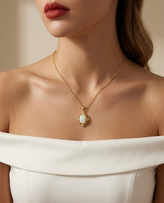 Close-up of a woman wearing a gold necklace with an opal pendant against a neutral background