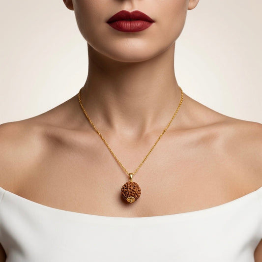 Gold necklace with a pendant worn by a model against a neutral background
