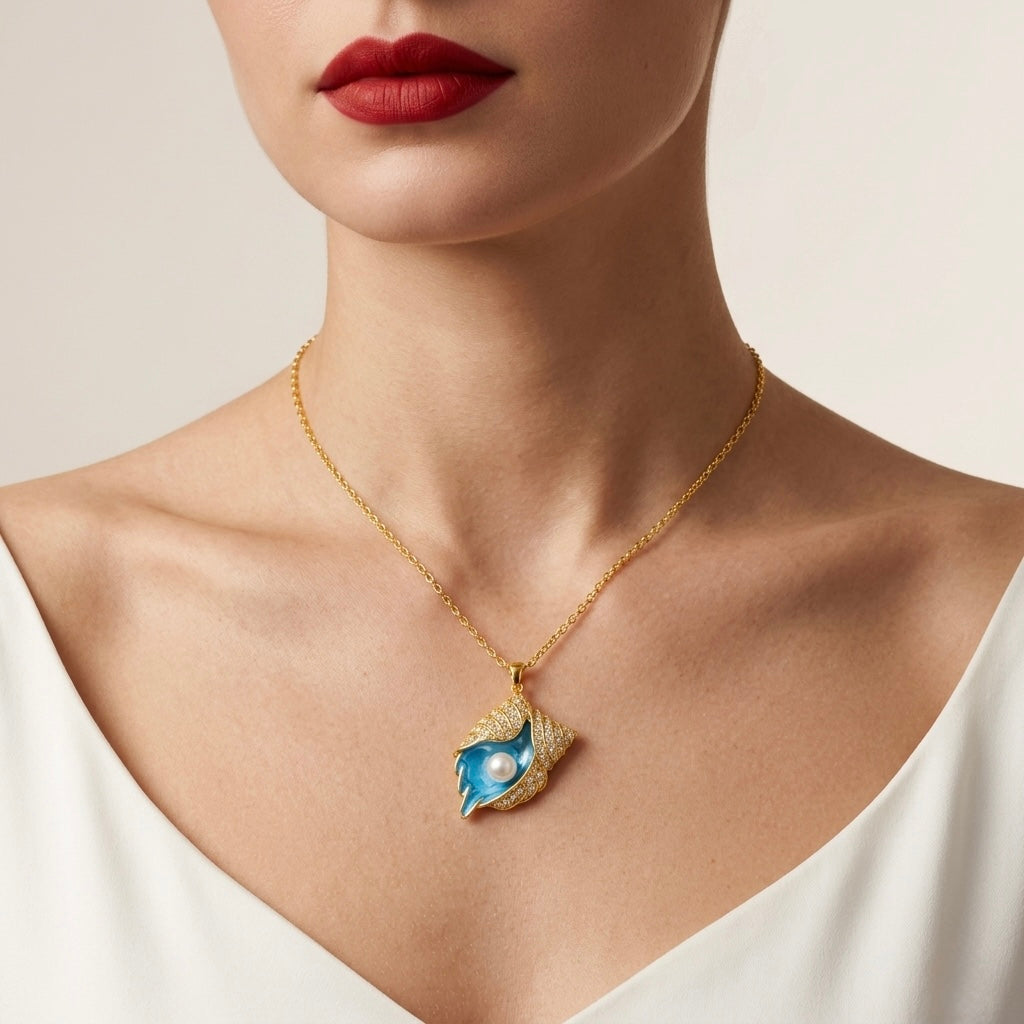 Gold necklace with a blue pendant worn by a person against a neutral background