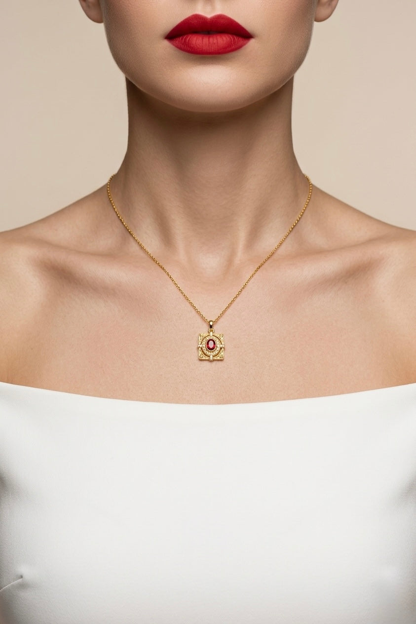 Gold necklace with a pendant worn by a model against a neutral background