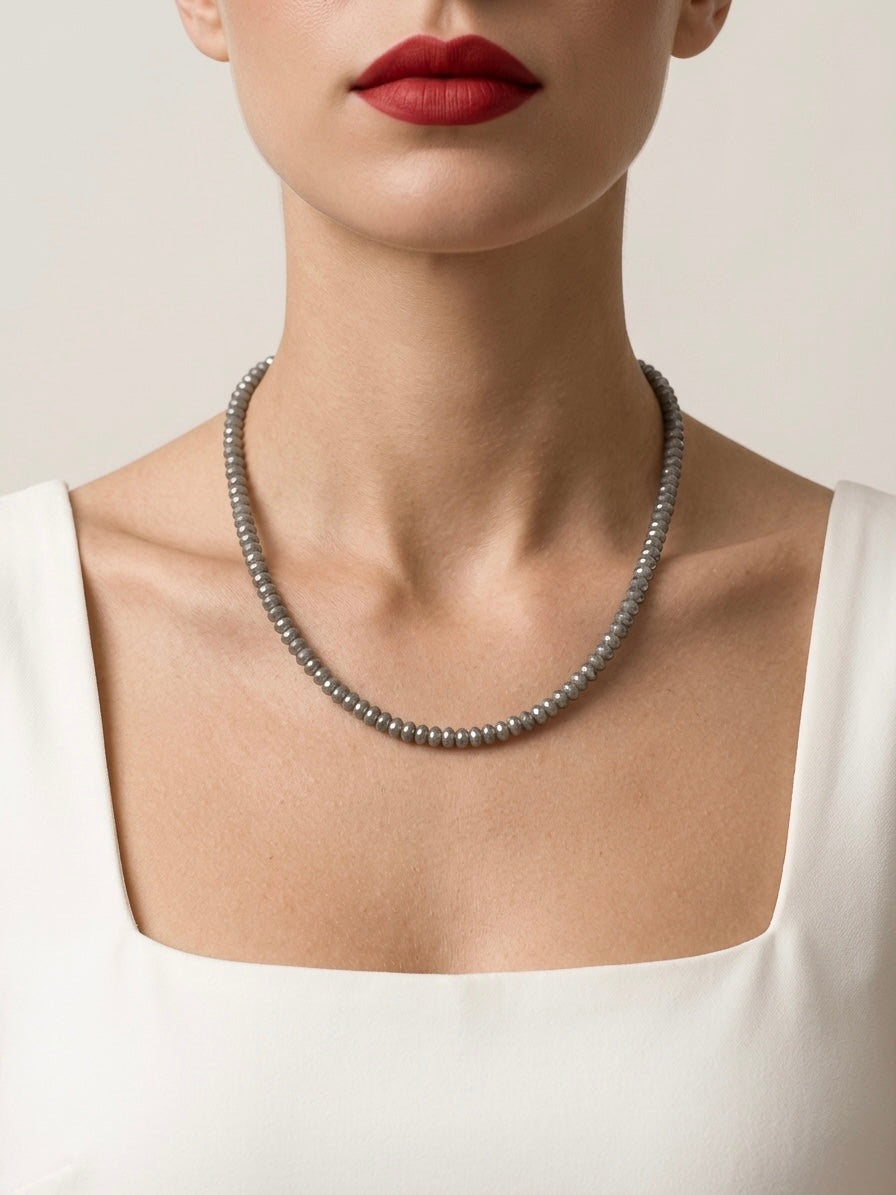 Pearl necklace worn by a person with a neutral background