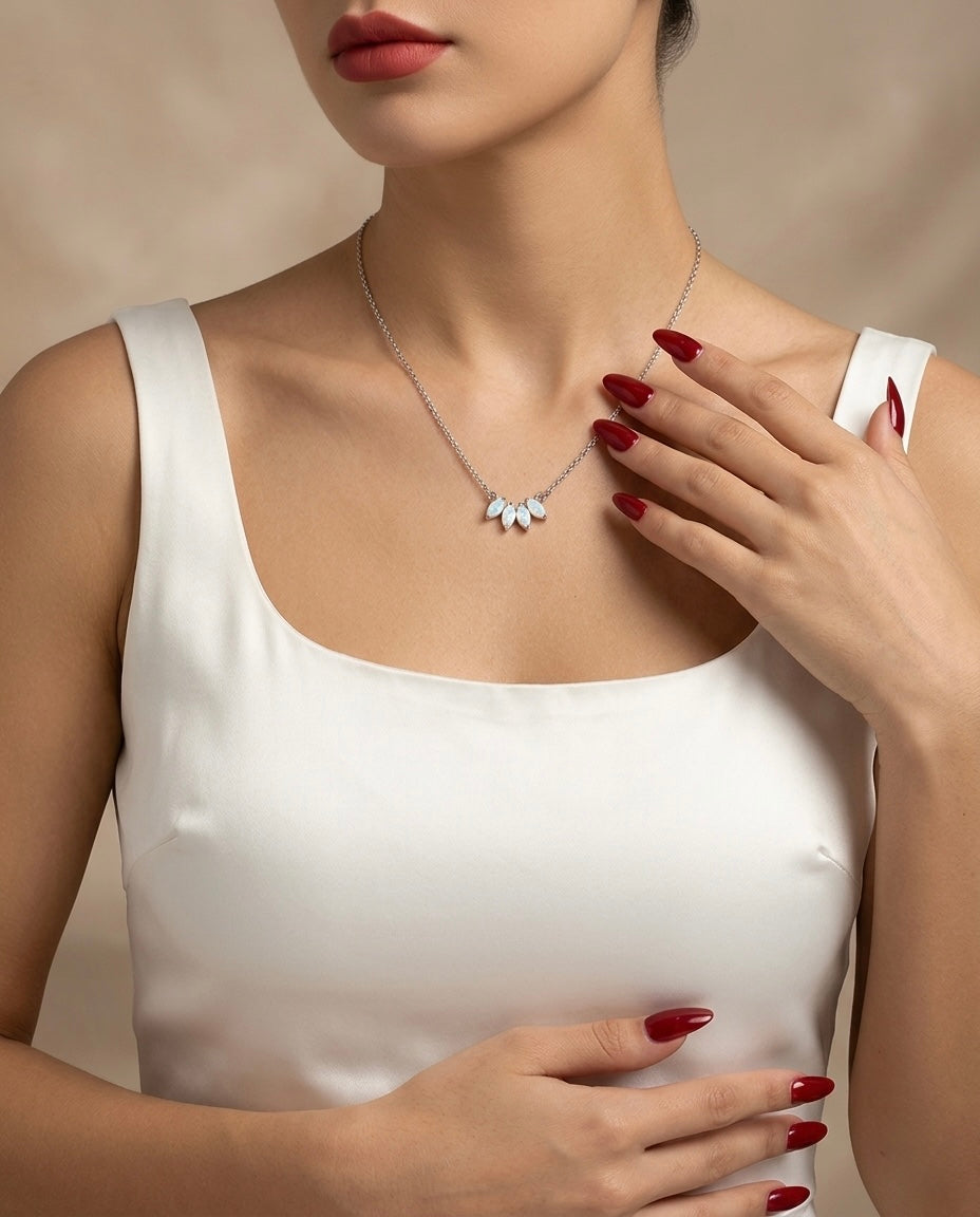 Woman wearing a delicate necklace with a neutral background