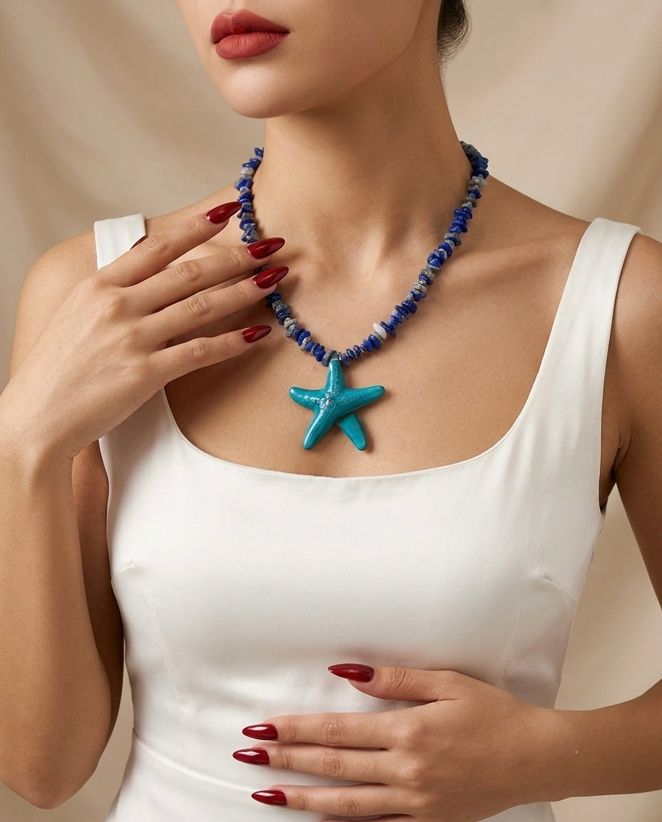 Woman wearing a blue starfish necklace against a neutral background