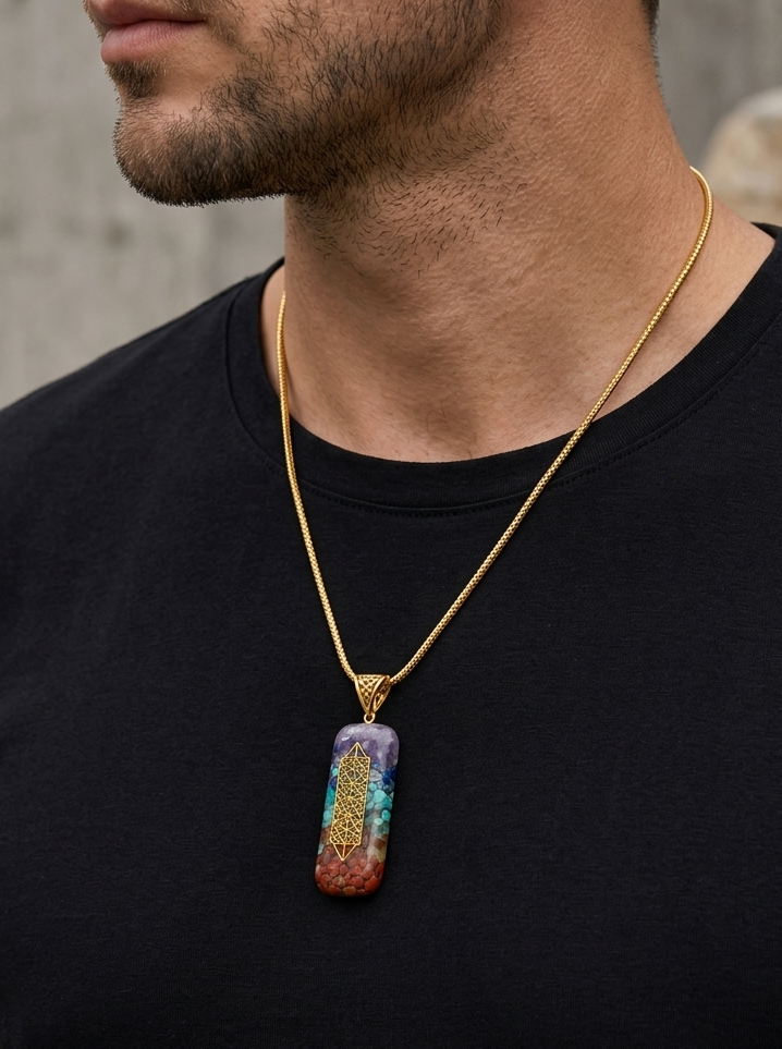 Man wearing a black t-shirt with a colorful pendant necklace against a neutral background