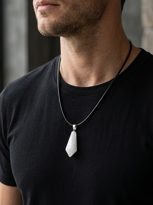 Man wearing a black t-shirt with a necklace featuring a white pendant.