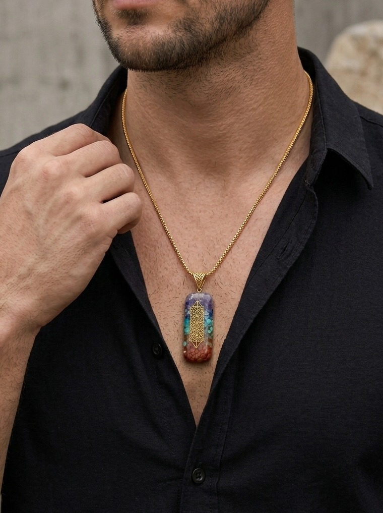 Man wearing a black shirt with a colorful pendant necklace against a neutral background