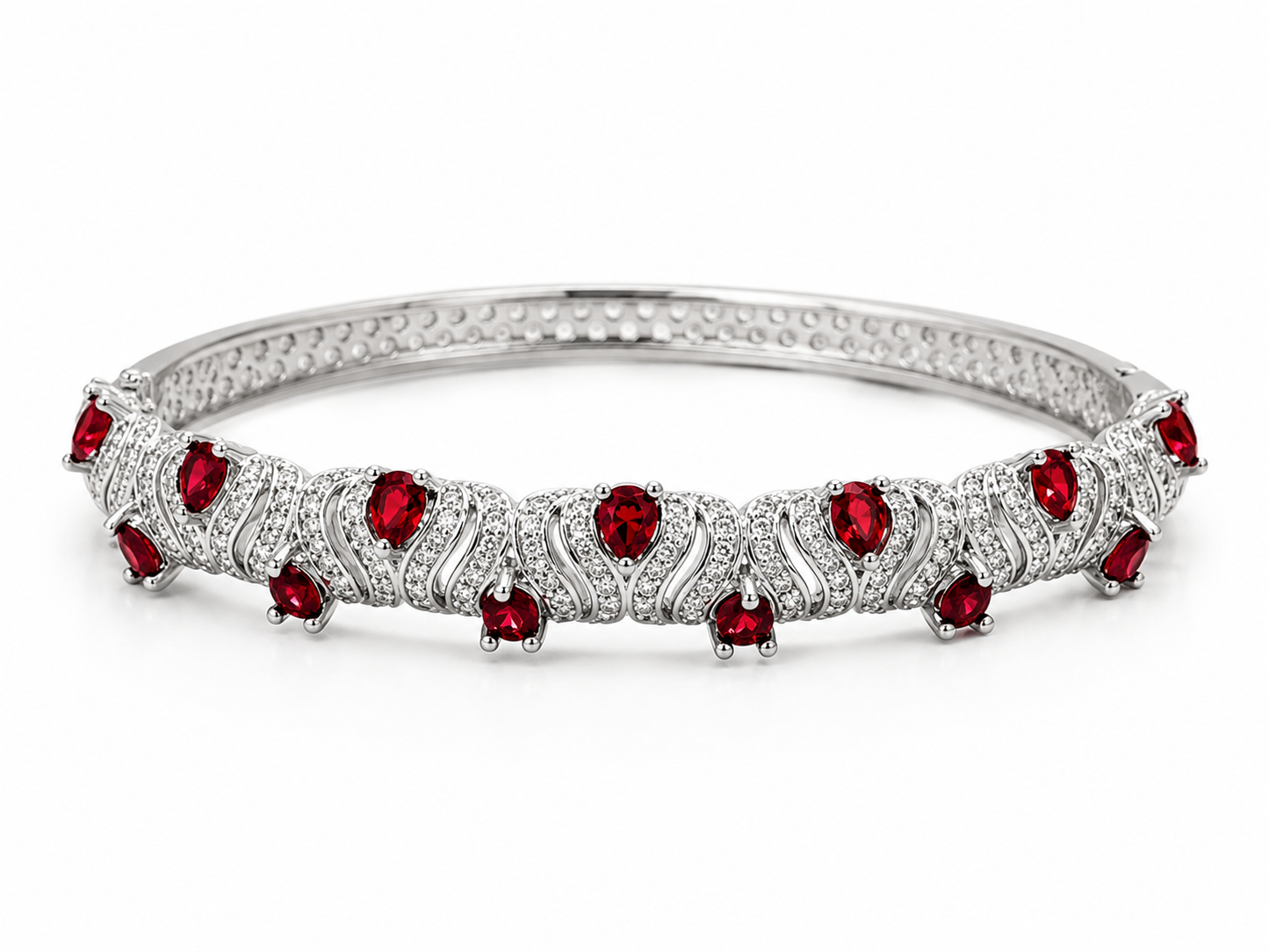 A silver-toned tennis-style bangle bracelet featuring a row of round-cut red gemstones and small clear stones in an openwork pattern, set against a plain white background.