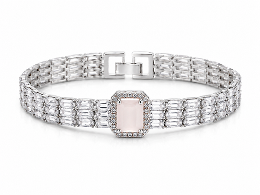A silver-toned link bracelet featuring a central rectangular pale pink gemstone surrounded by small clear stones, with baguette-cut side stones and a square clasp, shown on a white background.