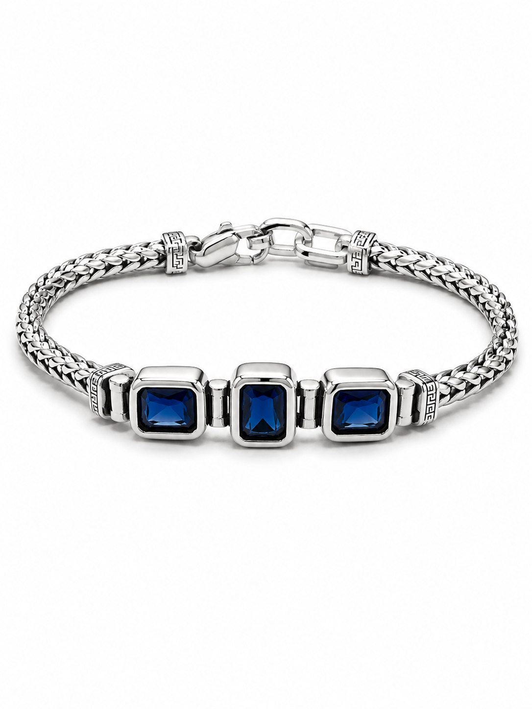 A silver-toned braided chain bracelet featuring three square bezel-set deep blue gemstones, displayed on a clean white background.