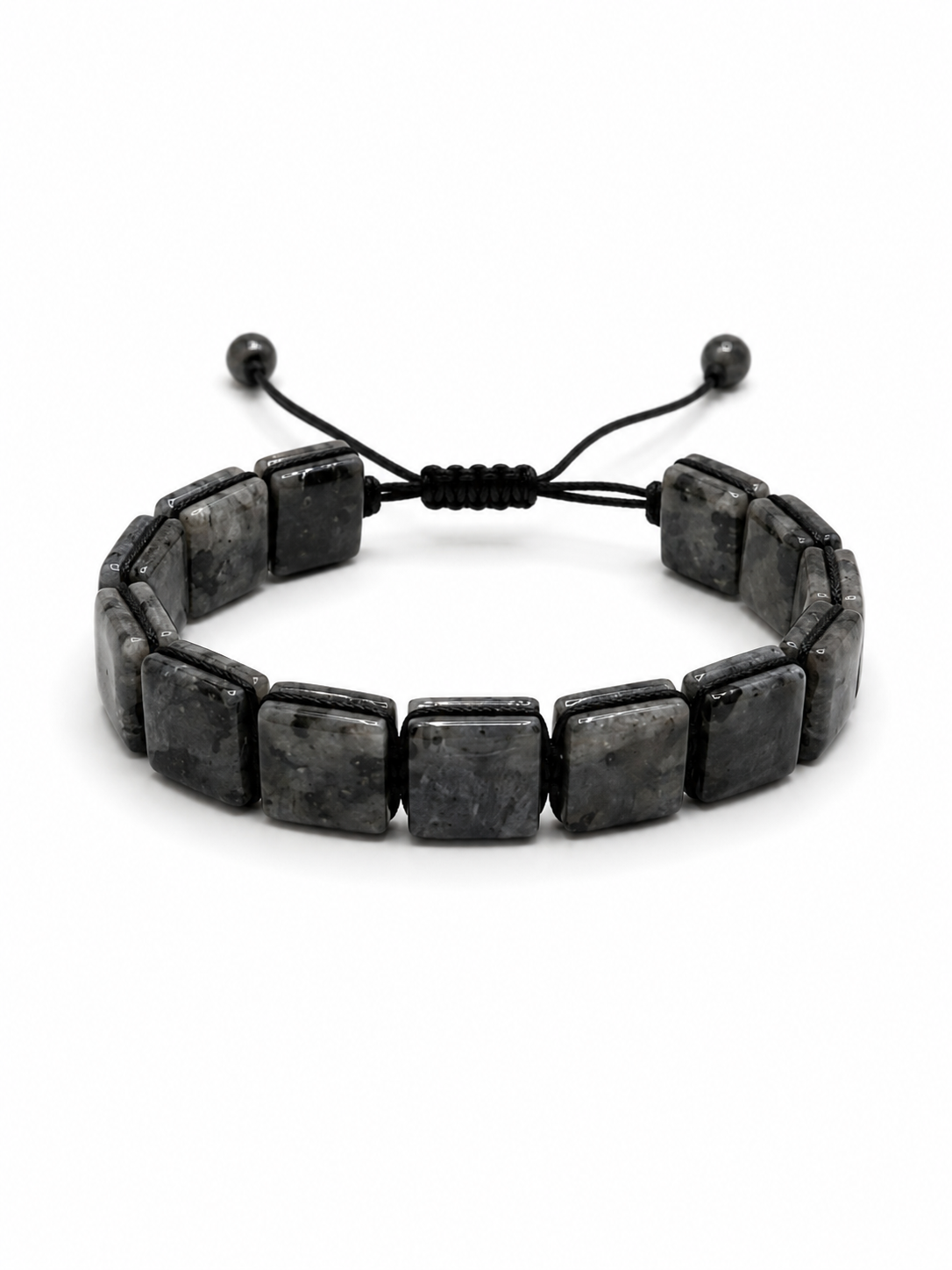 A black stone bracelet made of rectangular polished beads on a black adjustable cord, photographed on a clean white background.
