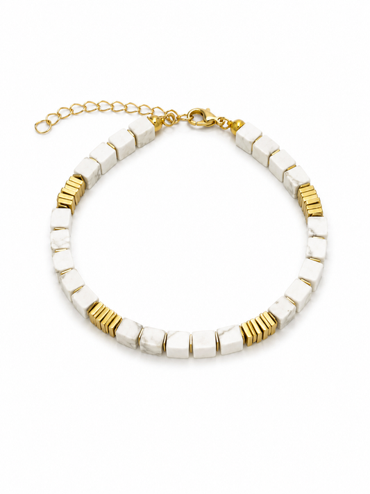 A beaded choker necklace featuring textured white square beads and polished gold spacer rings, with a gold lobster clasp and extender chain, shown on a plain white background.