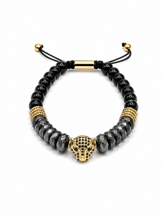 A men's beaded bracelet featuring faceted black beads, textured gold spacer beads, a central gold panther head charm, and an adjustable black cord slider with gold accents, shown on a white background.