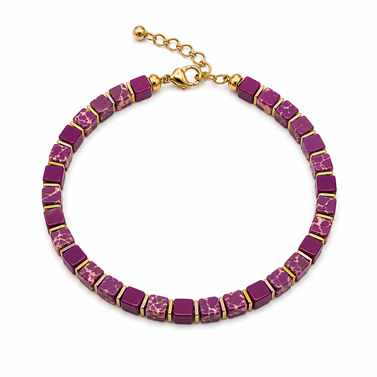 A chunky collar necklace featuring rectangular purple and magenta marbled beads set in gold-tone metal, with a gold clasp and extension chain, shown on a plain white background.