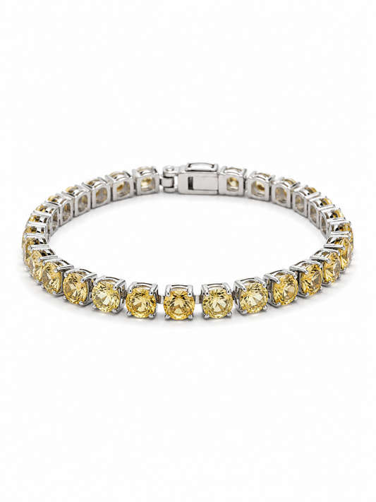 A tennis bracelet featuring round yellow gemstones in a silver-toned setting, arranged in a circular shape on a plain white background.