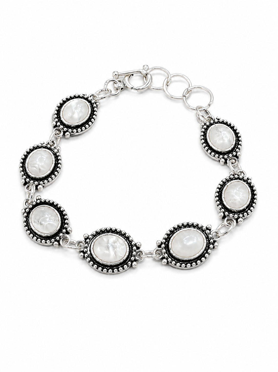 A silver-toned bracelet featuring five oval links with black beaded borders and white cameo-style faces in the center, displayed on a clean white background.