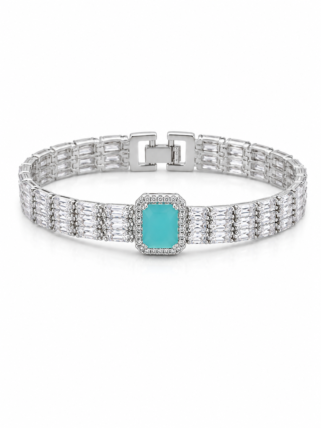 A silver-toned tennis-style bracelet featuring a central rectangular turquoise stone surrounded by small clear stones, with a baguette-set band and a sliding clasp, shown on a white background.
