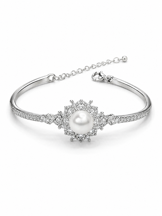 A silver-toned bangle bracelet featuring a central white pearl surrounded by clear pavé stones, with an adjustable chain clasp at the back, shown on a clean white background.