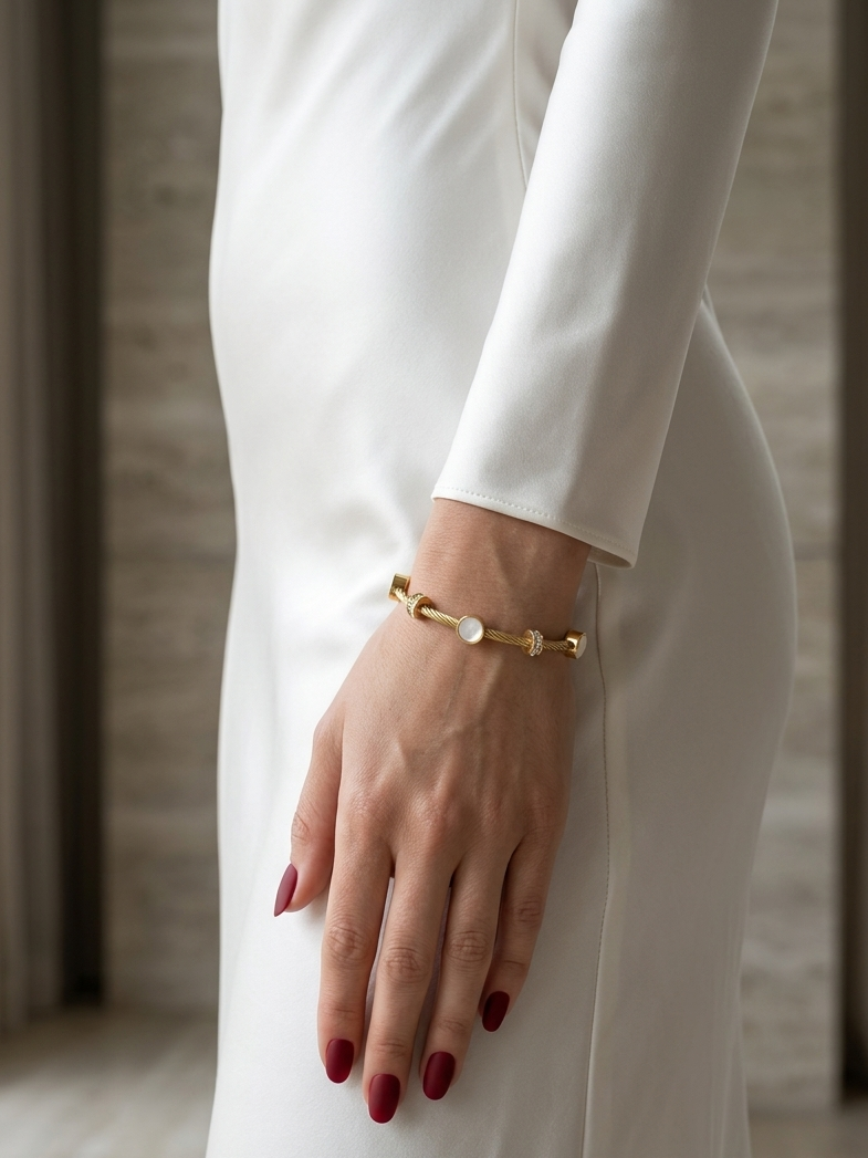 Close-up of the Natural White Moonstone Cable Bangle Bracelet worn on a woman's wrist, featuring genuine White Moonstone cabochons and Gold PVD-Plated (Non-Tarnish) design.