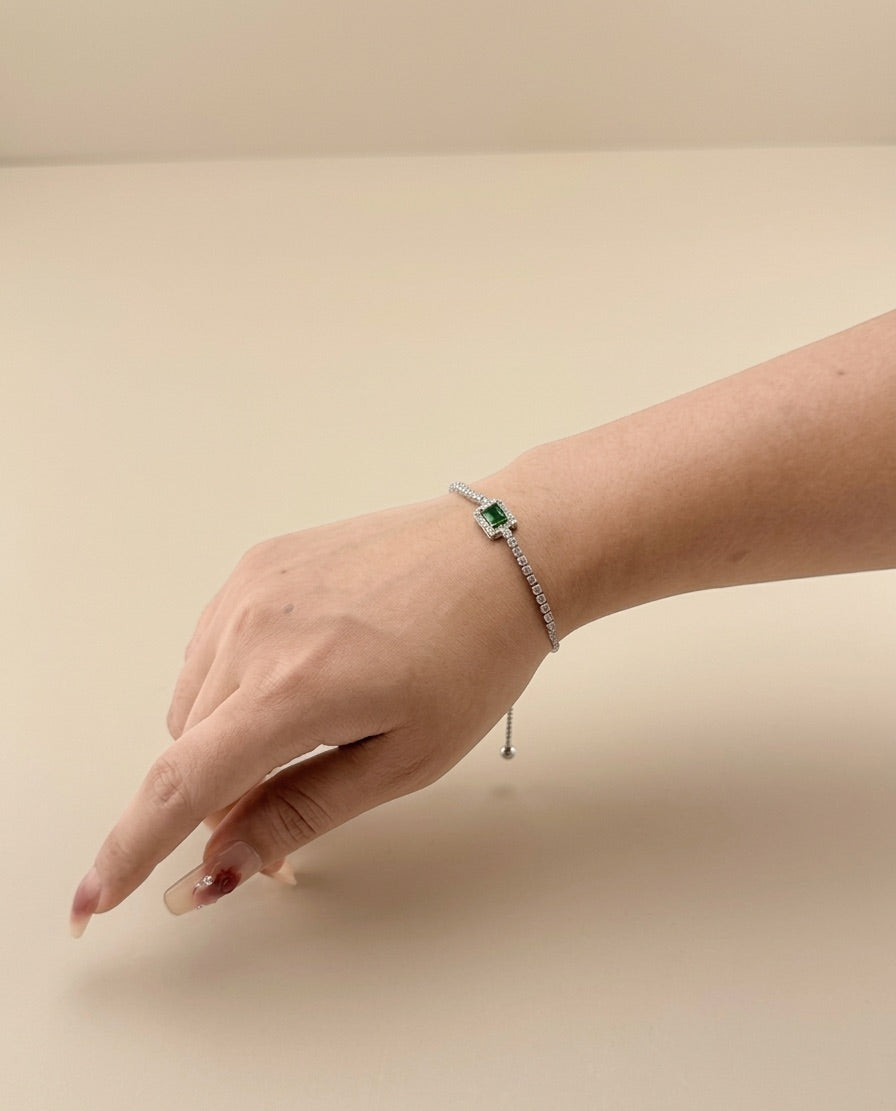Hand wearing a bracelet on a beige background