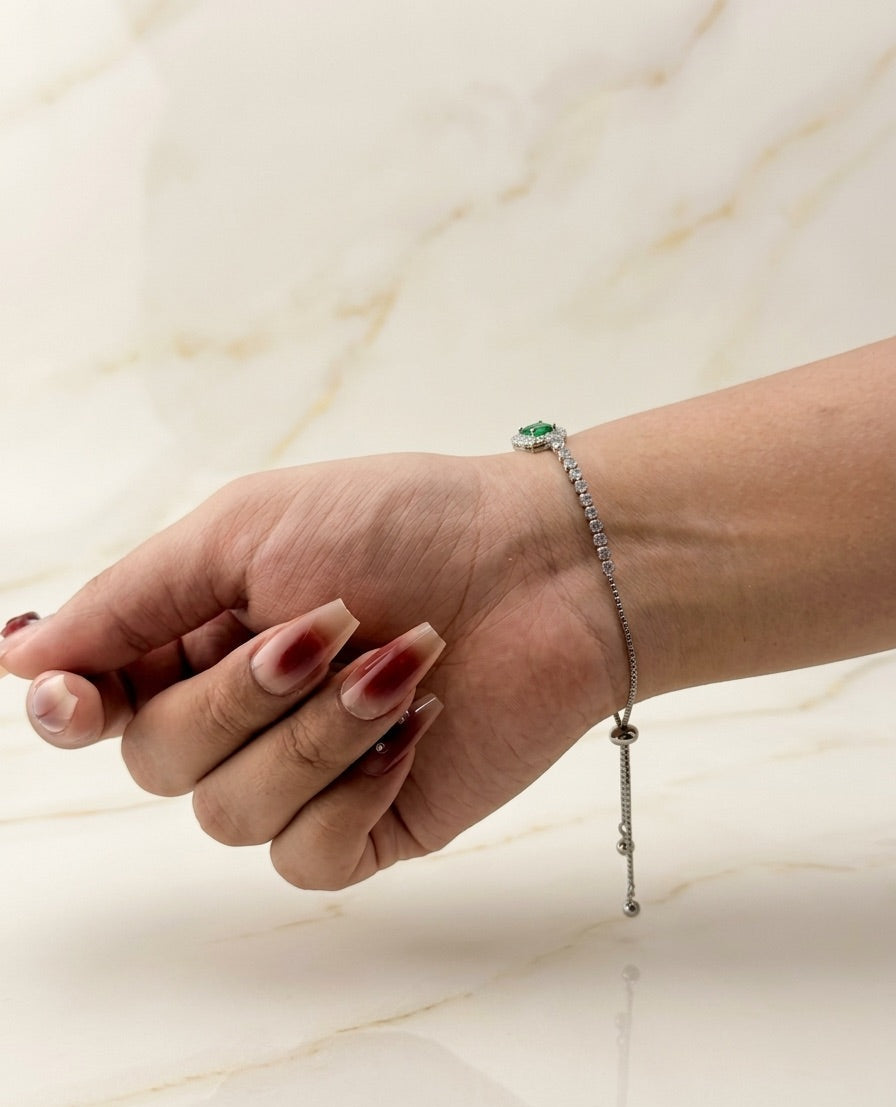 Hand wearing a bracelet on a light marble background