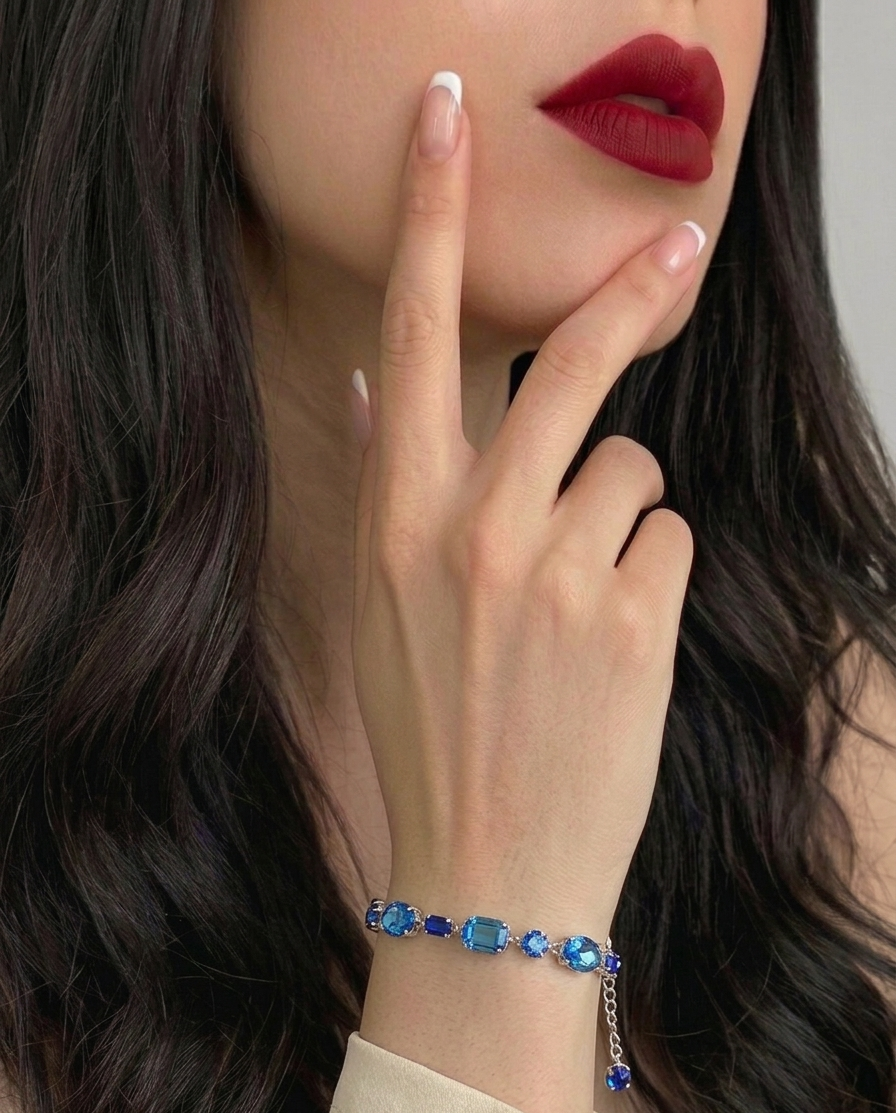 Woman wearing a blue bracelet with a neutral background