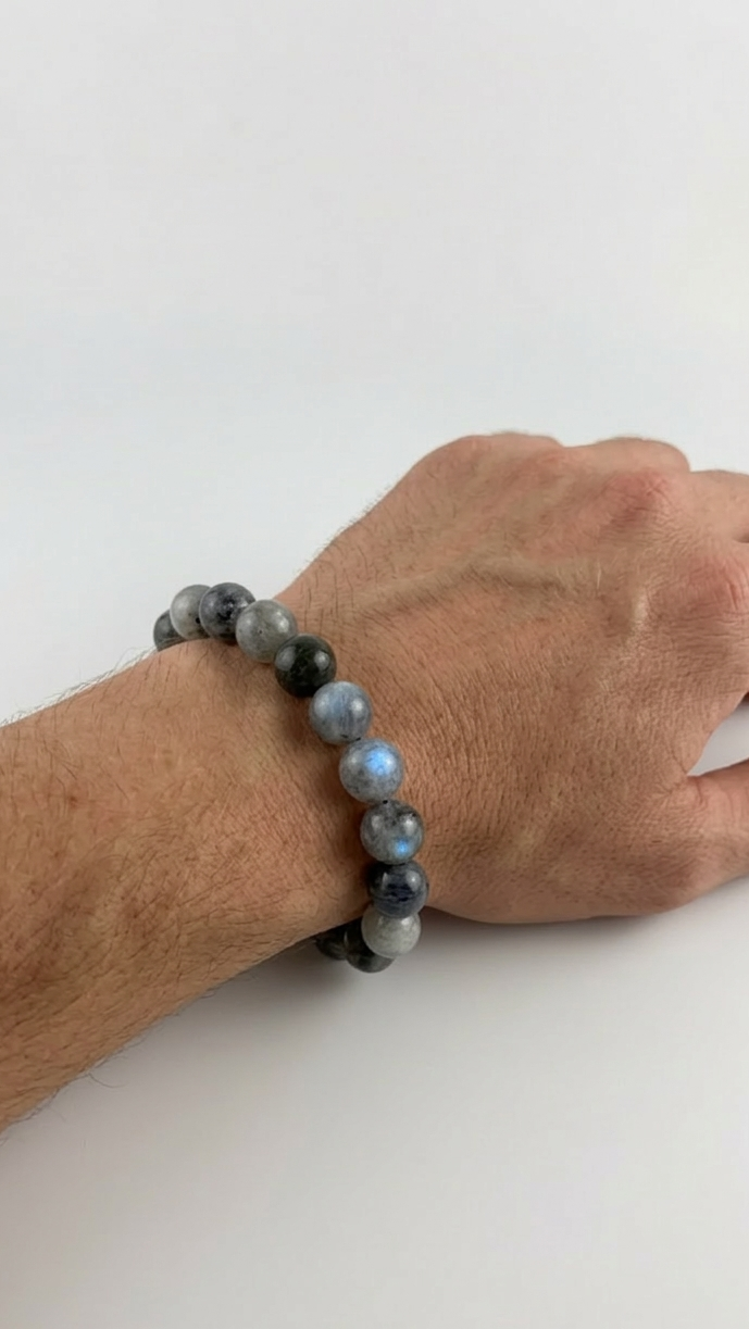 Hand wearing a bracelet with black beads on a white background