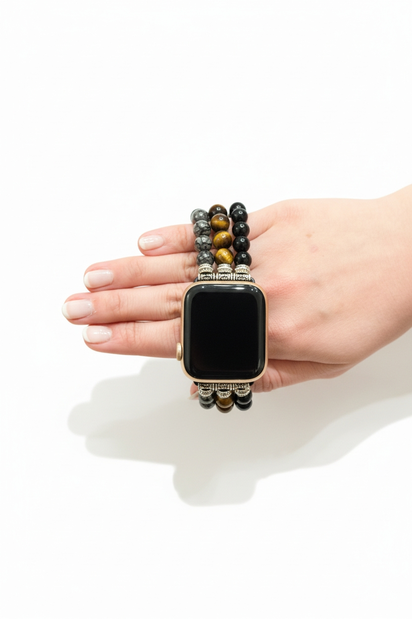 Smartwatch with a decorative beaded band held in a hand on a white background