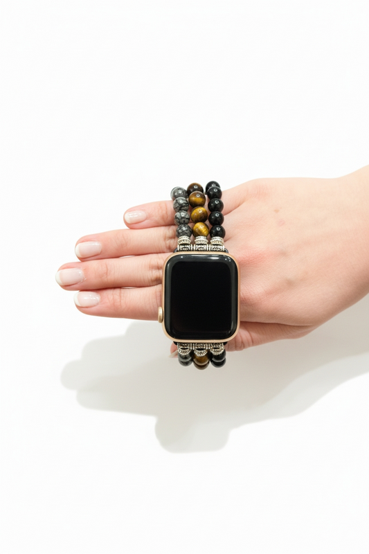 Smartwatch with a decorative beaded band held in a hand on a white background