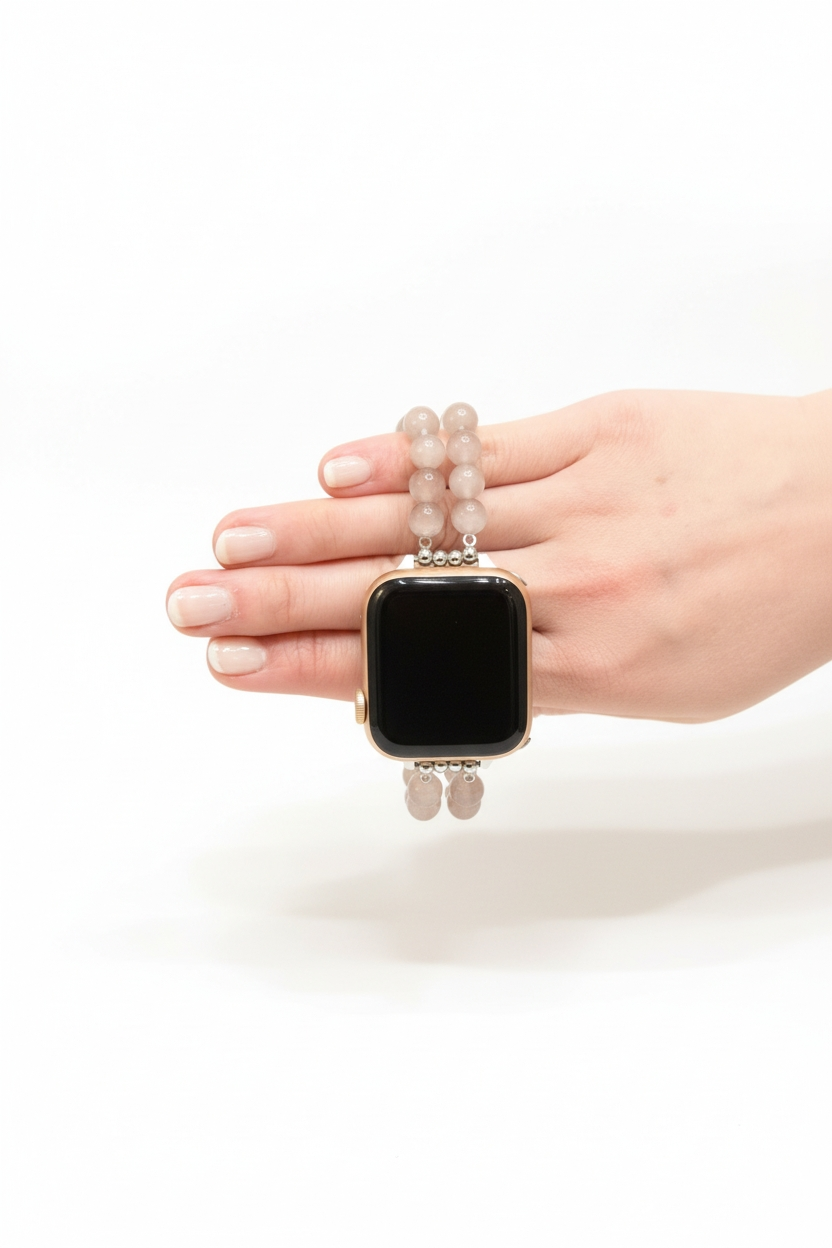 Hand holding a smartwatch with a beaded band on a white background